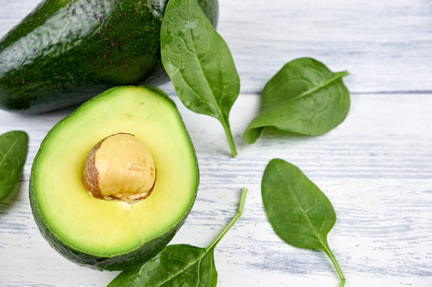 Slices of avocado on white background. Whole and half with leaves. - 写真・画像