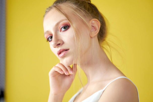 mladá dívka na žlutém pozadí. krásný make-up, zářivý obraz, místo pro text - Fotografie, Obrázek