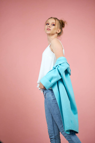 portrait of a sad girl in the studio on a pink background. turquoise clothing. fresh fashion colors - Photo, Image