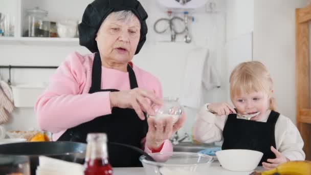 Krep yapmak aile. Yaşlı bir kadın eklemek şeker hamur içinde - Video, Çekim