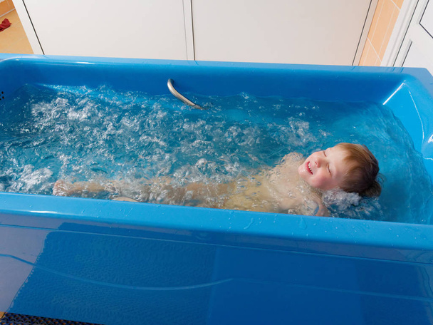 babyjongen is het nemen van een bad met bubbels. Jacuzzi bubbelbad procedure. - Foto, afbeelding