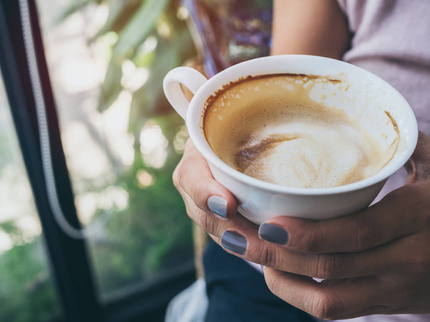 Manos de mujer sosteniendo una taza de café caliente blanco
 - Foto, Imagen