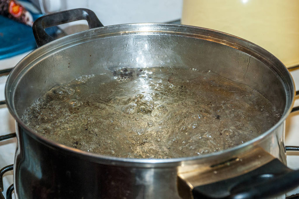 Agua hirviendo para espaguetis o sopa en una cacerola de acero inoxidable en la cocina de la casa
 - Foto, Imagen