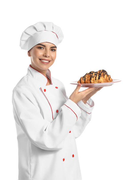 Young female confectioner with tasty croissants on white background - Foto, afbeelding