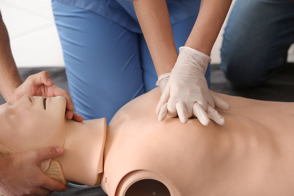 Instructor demonstrating CPR on mannequin at first aid training course - Valokuva, kuva