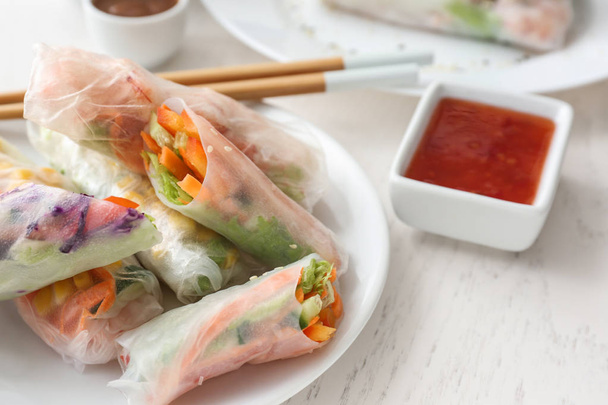 Tasty spring rolls with sauce on table - Фото, изображение