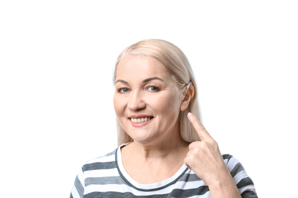 Mature woman with hearing aid on white background - Photo, Image