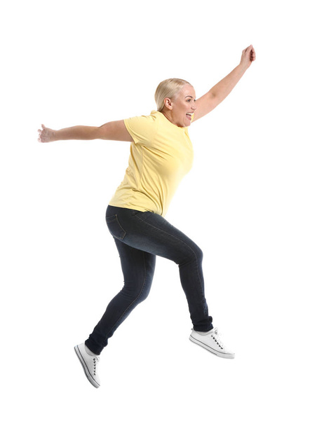 Kypsä nainen hyppää valkoista taustaa vasten
 - Valokuva, kuva