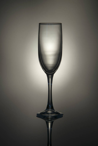 Silhouette of a champagne glass on a gray-brown background. - Foto, imagen