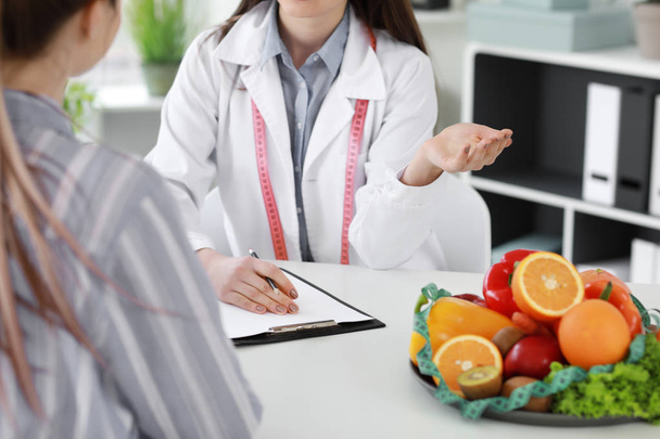 Young woman visiting nutritionist in weight loss clinic - Zdjęcie, obraz