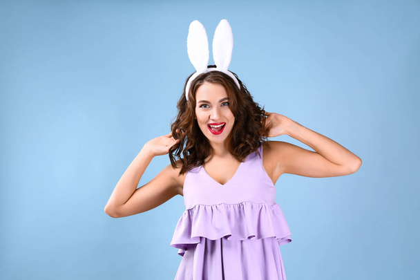 Beautiful young woman with bunny ears on color background - Photo, Image