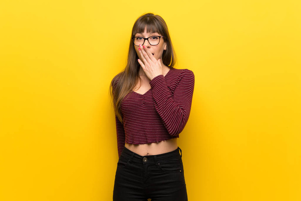 Woman with glasses over yellow wall smiling a lot - Фото, изображение