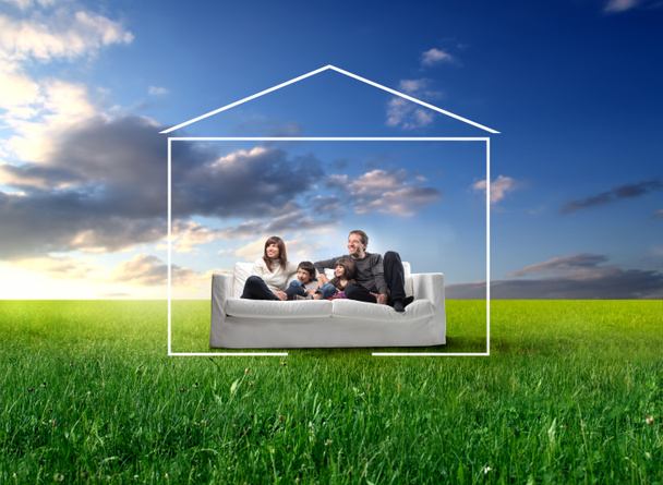 family sitting on a sofa on meadow - Photo, Image