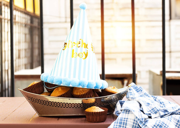 ボートに乗ってアラビア砂糖の自家製マフィン形青い帽子、誕生日の少年概念と銀のプレート - 写真・画像