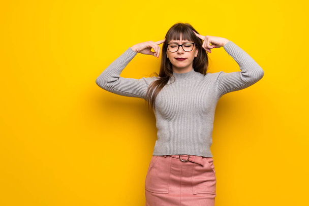 Žena s brýlemi přes žlutou zeď pochybnosti a myšlení - Fotografie, Obrázek