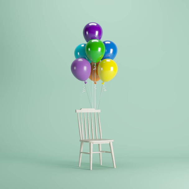 緑のパステルの背景に浮かぶカラフルな風船を持つ木製の椅子。最小限のパーティーコンセプトアイデア. - 写真・画像