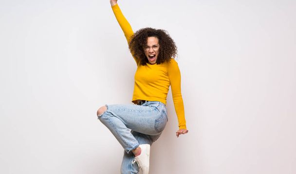 Dominican woman with curly hair jumping over isolated white back - Fotoğraf, Görsel