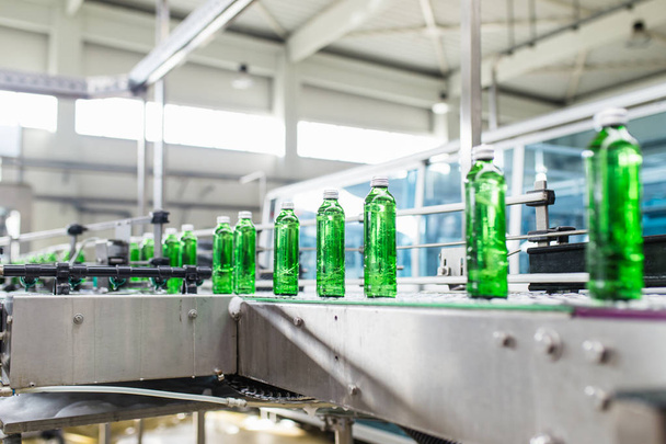 Butelkowanie-linia butelkowania wody do przetwarzania i butelkowania czystej wody źródlanej w butelkach z zielonego szkła. Selektywna koncentracja.  - Zdjęcie, obraz