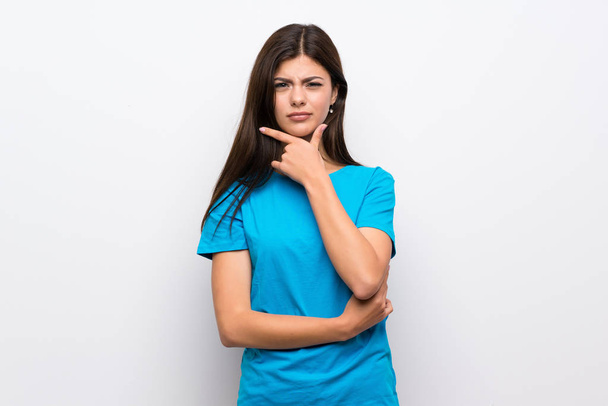 Teenager girl with blue shirt thinking - 写真・画像