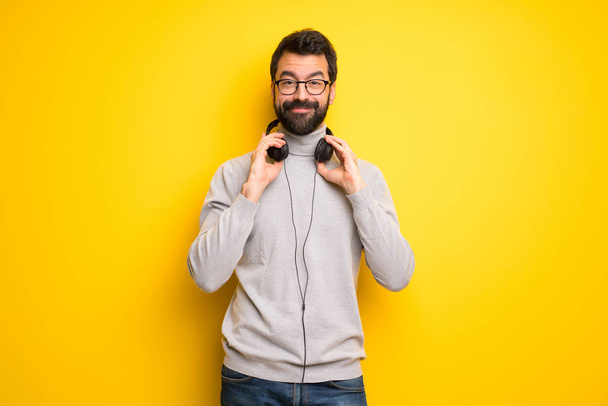 Άνθρωπος με γένια και ζιβάγκο με ακουστικά - Φωτογραφία, εικόνα