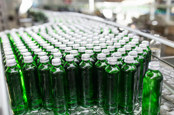 Butelkowanie-linia butelkowania wody do przetwarzania i butelkowania czystej wody źródlanej w butelkach z zielonego szkła. Selektywna koncentracja.  - Zdjęcie, obraz