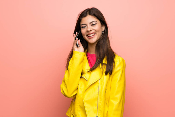 Ragazza adolescente oltre muro rosa mantenere una conversazione con il telefono cellulare
 - Foto, immagini