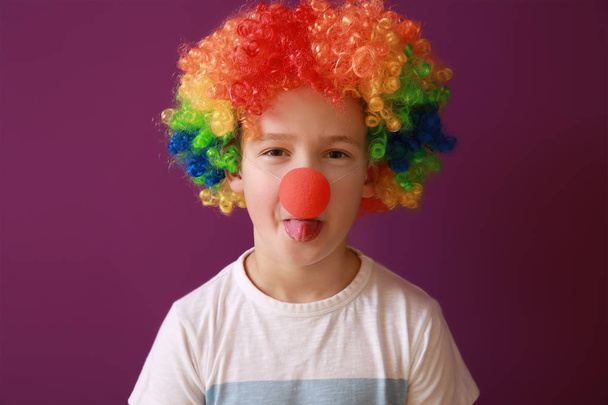 Niño con un disfraz divertido en el fondo de color. Celebración del Día de los Inocentes
 - Foto, imagen