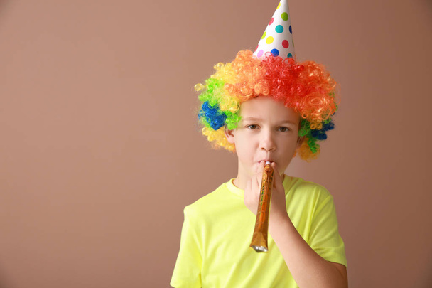 Niño con un disfraz divertido en el fondo de color. Celebración del Día de los Inocentes
 - Foto, imagen