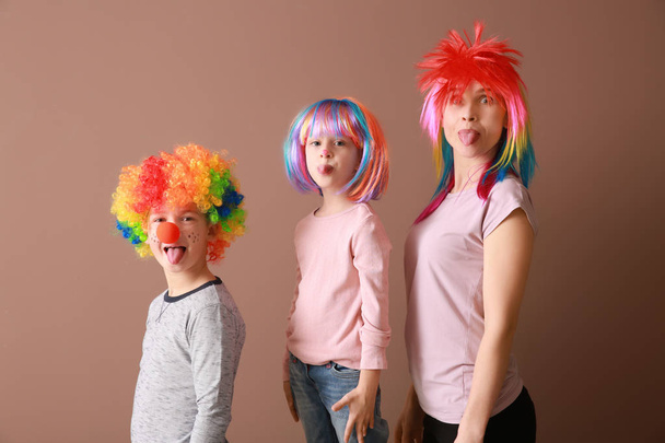 Familie in lustiger Verkleidung auf farbigem Hintergrund. Aprilscherz-Fest - Foto, Bild