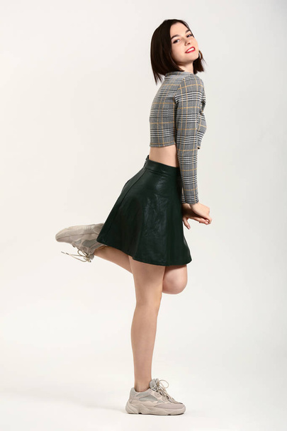 schöne junge Frau in modernen stilvollen Kleidern auf hellem Hintergrund - Foto, Bild
