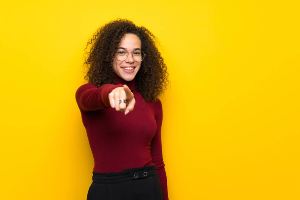 Dominican woman with turtleneck sweater points finger at you with a confident expression - Foto, imagen