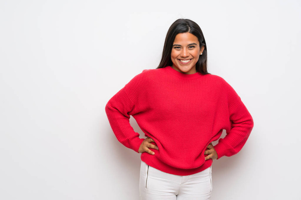 Young Colombian girl with red sweater posing with arms at hip and smiling - Foto, Imagem