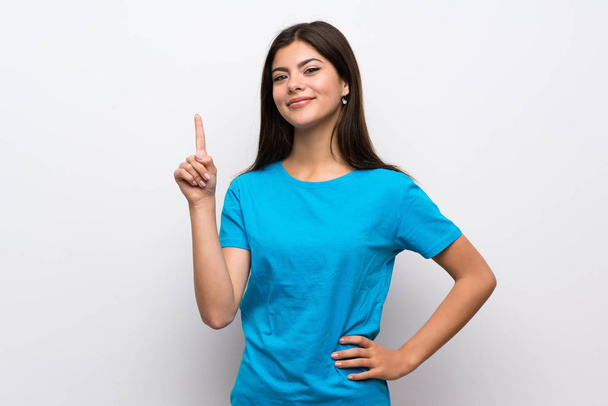 Дівчина-підліток з блакитною сорочкою, що показує і піднімає палець в знак кращих
 - Фото, зображення