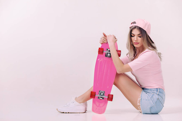 beautiful woman in white t-shirt with pink skateboard - Fotó, kép
