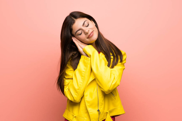 Chica adolescente sobre la pared de color rosa haciendo gesto de sueño en la expresión dorable
 - Foto, imagen