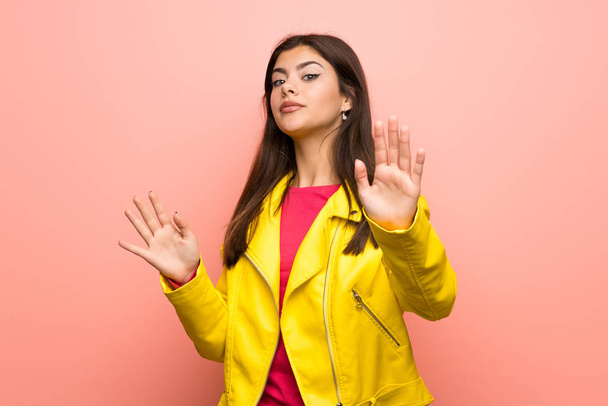 Ragazza adolescente oltre muro rosa nervoso allungamento delle mani davanti
 - Foto, immagini