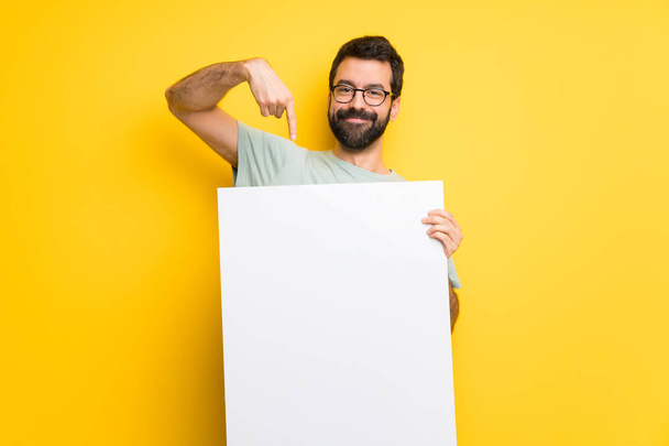 Mann mit Bart und grünem Hemd hält ein Plakat in der Hand, um ein Konzept einzufügen - Foto, Bild