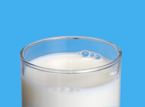 Milk glass on blue background. - Fotó, kép