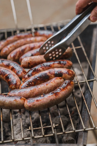 Grilling sausages on barbecue grill outdoor - Photo, Image