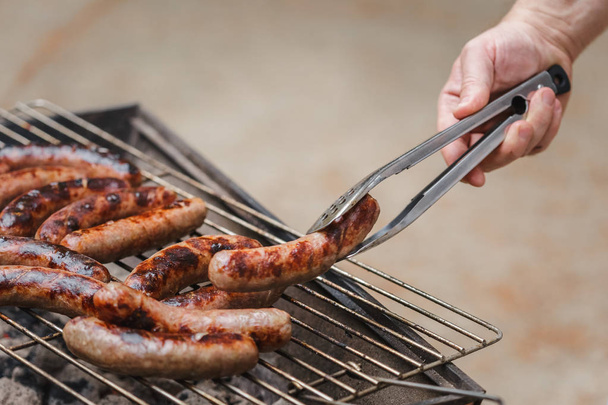 Grilling sausages on barbecue grill outdoor - Photo, Image
