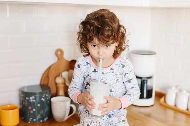 Little girl wearing pajamas drinking milk - Photo, Image