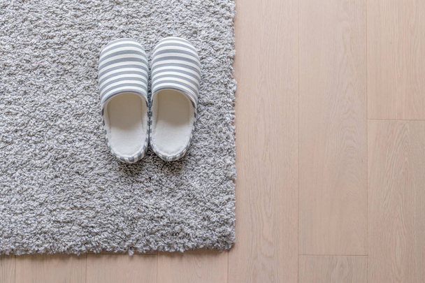 Παντόφλες σε γκρίζο χαλί στο πάτωμα - Φωτογραφία, εικόνα