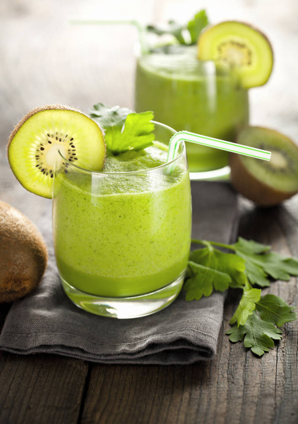 glasses with green homemade kiwi smoothies on wooden table  - Photo, image