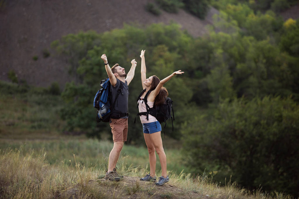 A man and a woman are hiking in the mountains with backpacks. - Photo, Image