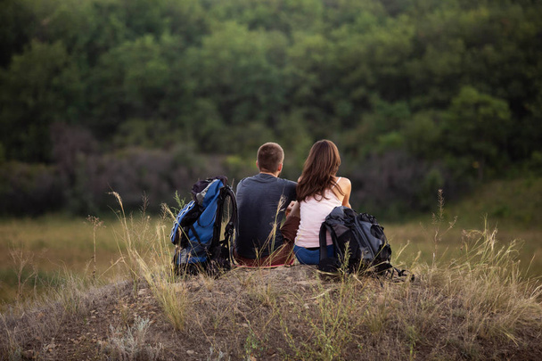 A man and a woman are hiking in the mountains with backpacks. Si - Photo, Image