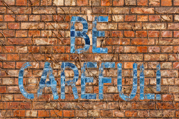 Écriture conceptuelle montrant Soyez prudent. Texte de la photo d'affaires en s'assurant d'éviter tout risque potentiel d'accident ou de préjudice Brick Wall art comme Graffiti appel motivationnel écrit sur le mur
. - Photo, image