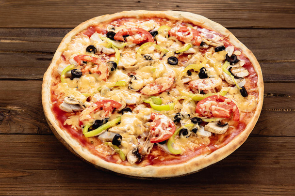 Pizza apetitosa sobre fondo de madera
 - Foto, Imagen