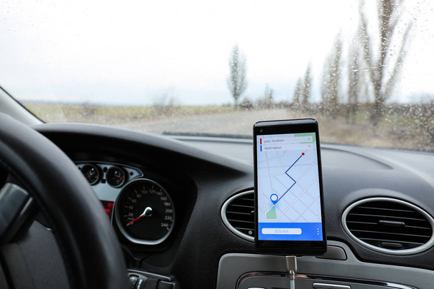 Мобільний телефон, що відображає карту з маршрутом на екрані для водія автомобіля
 - Фото, зображення