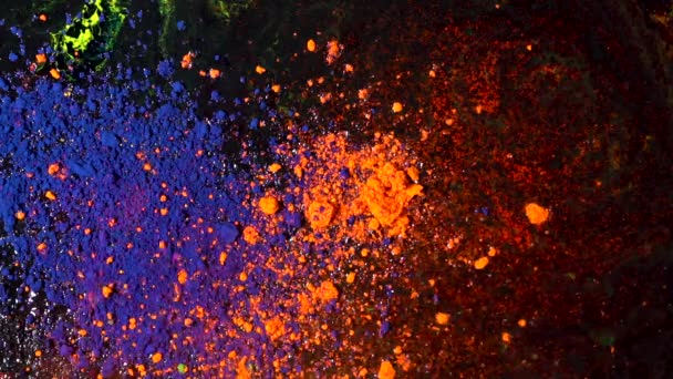 Φωτεινή έγχρωμη έκρηξη σκόνης σε μαύρο φόντο, καλλιτεχνική αντίληψη. Κίνηση από μπλε και πορτοκαλί μελάνια σκόνης, πολύχρωμη, φωτεινή υφή. - Πλάνα, βίντεο