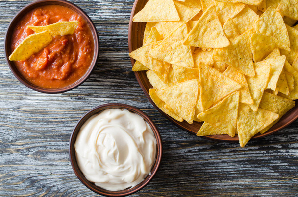 Nachos corn chips with spicy tomato and cheese sauces. - Φωτογραφία, εικόνα